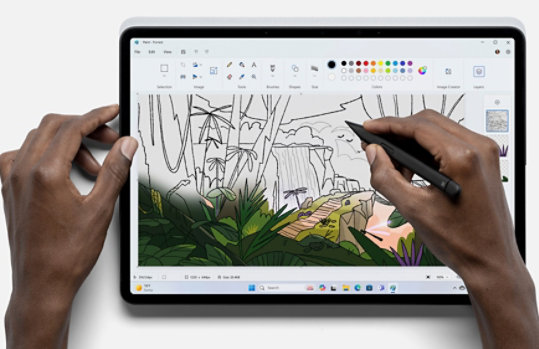 Person holding a pen using the Paint app to create an image