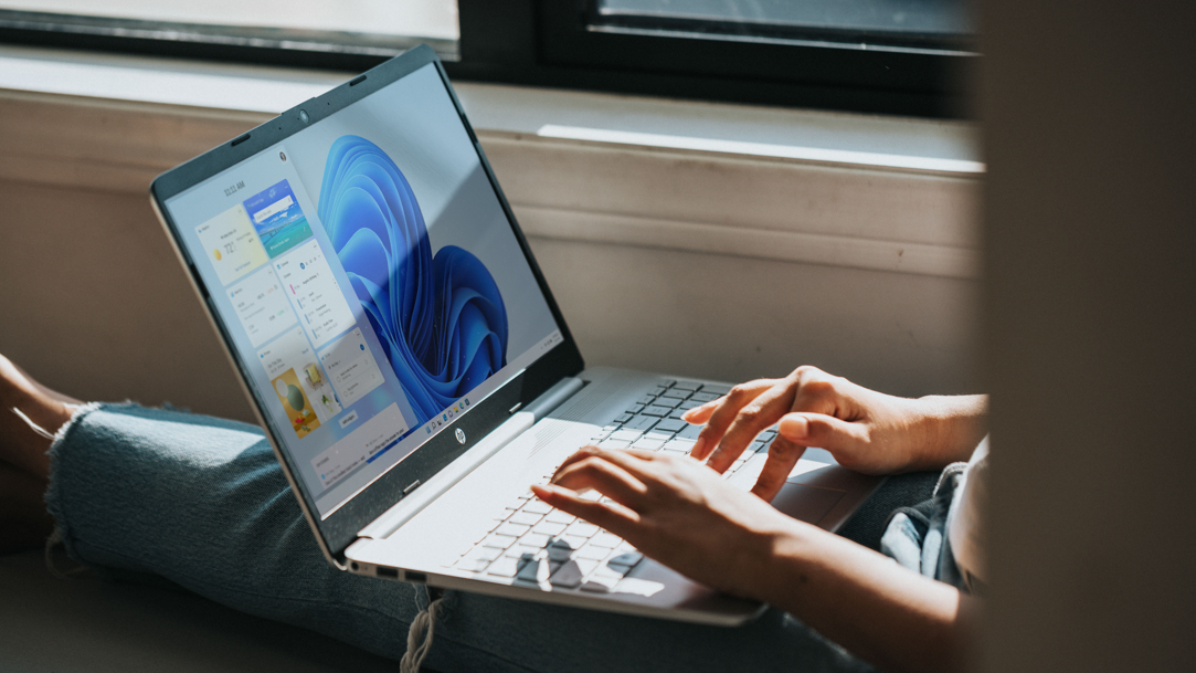 Person using Windows 11 computer on lap