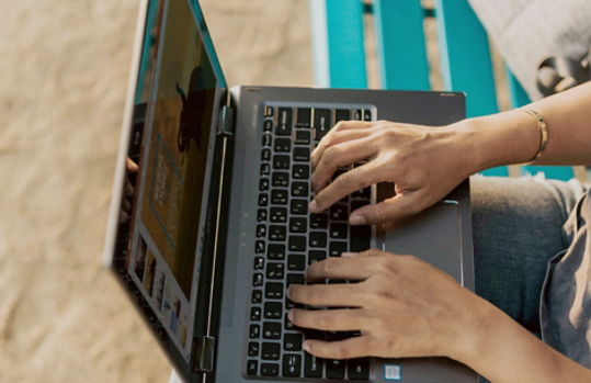 Person using Windows laptop while sitting on a bench