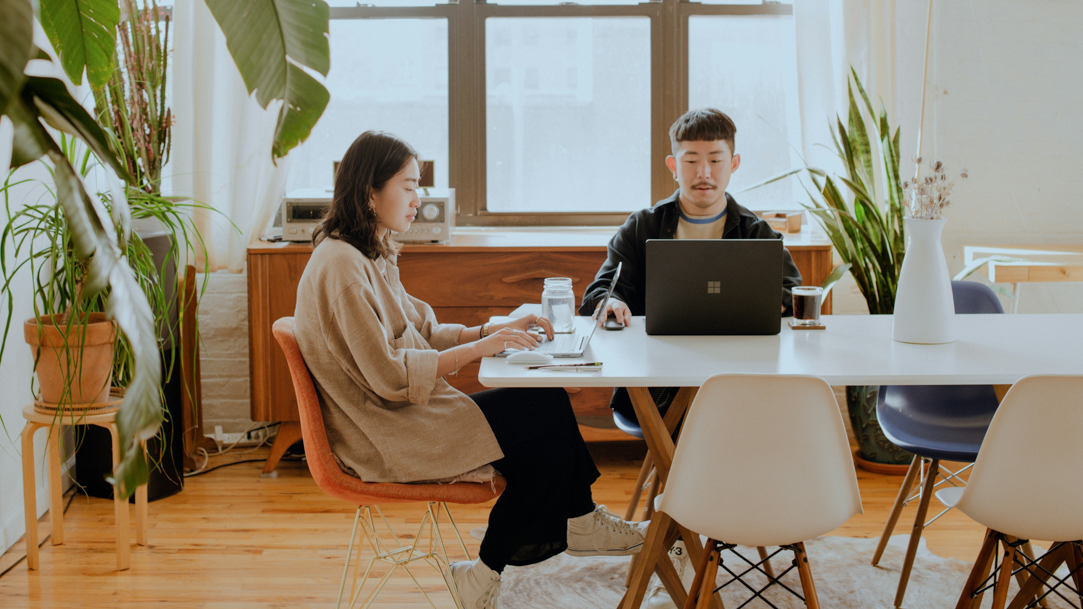 Two people using Surface devices on table