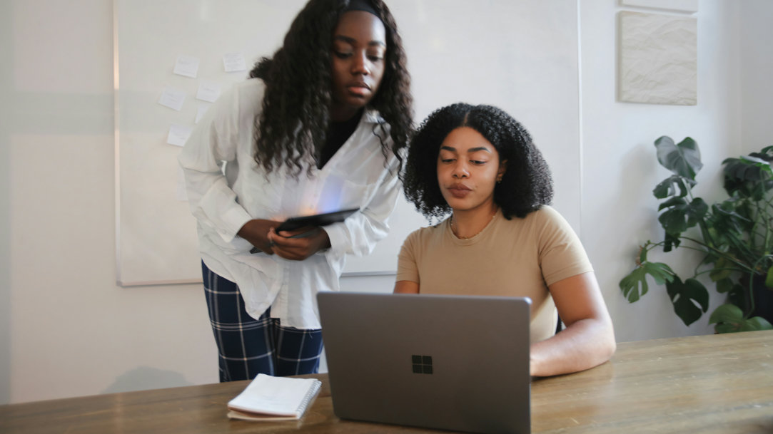 Two women collaborating on a Microsoft Surface laptop