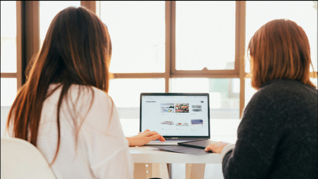 Two women sitting together looking at a laptop screen