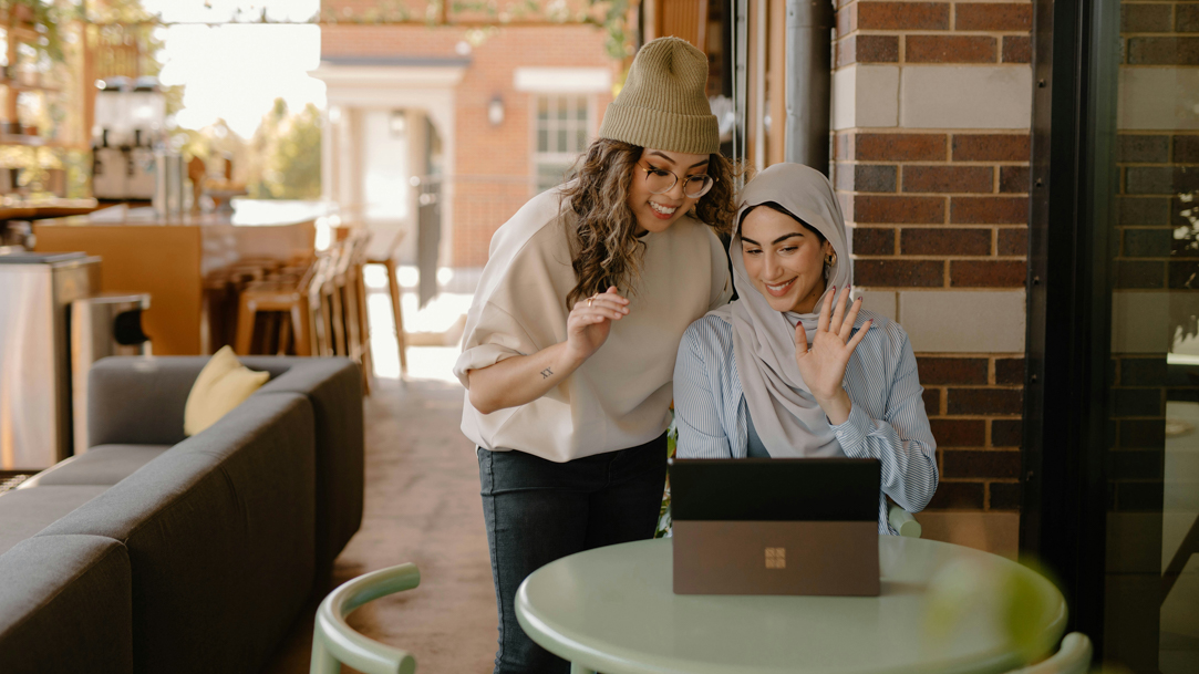 Two women using a 2-in-1 PC at a table