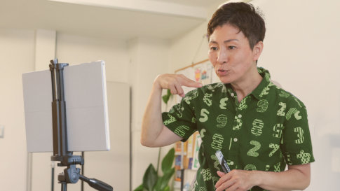 A woman using accessibility features while standing in front of a mounted PC