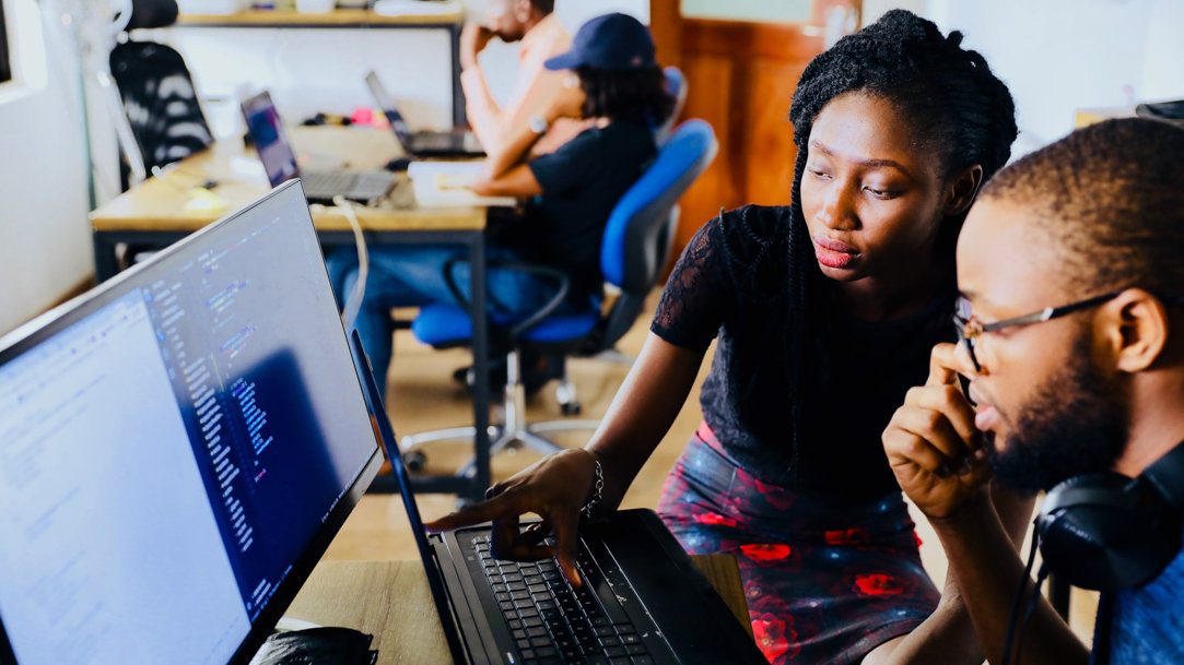 Woman and man working in front of computer monitor