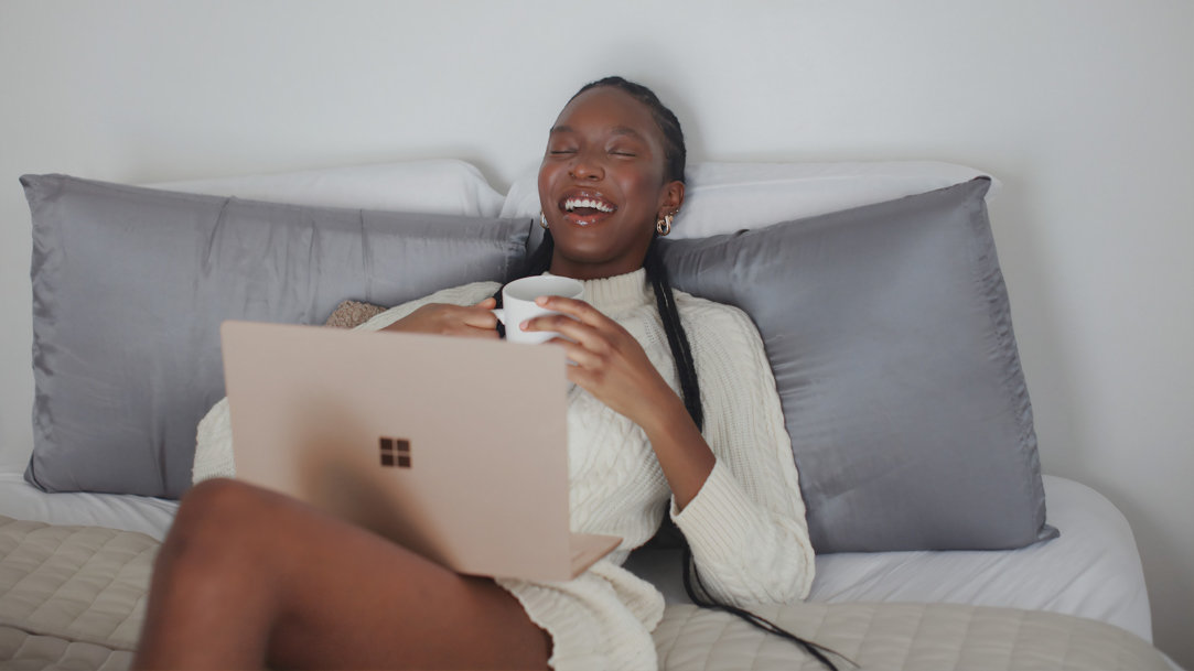 Two people using a Surface Pro 2-in-1 PC while sitting on a stoop