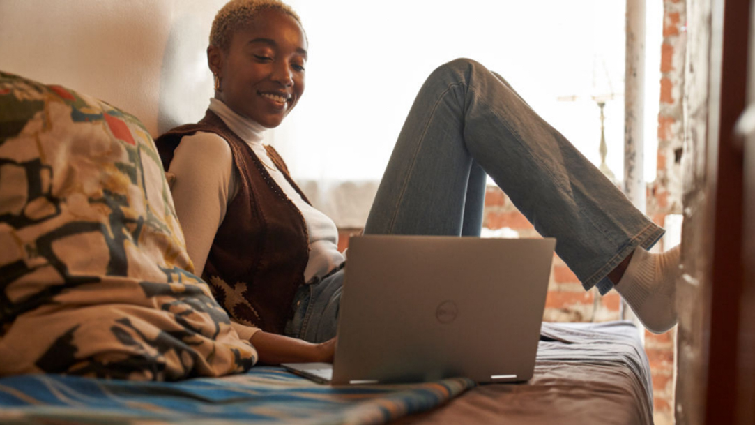 Woman sitting on a bed with her computer gaming online