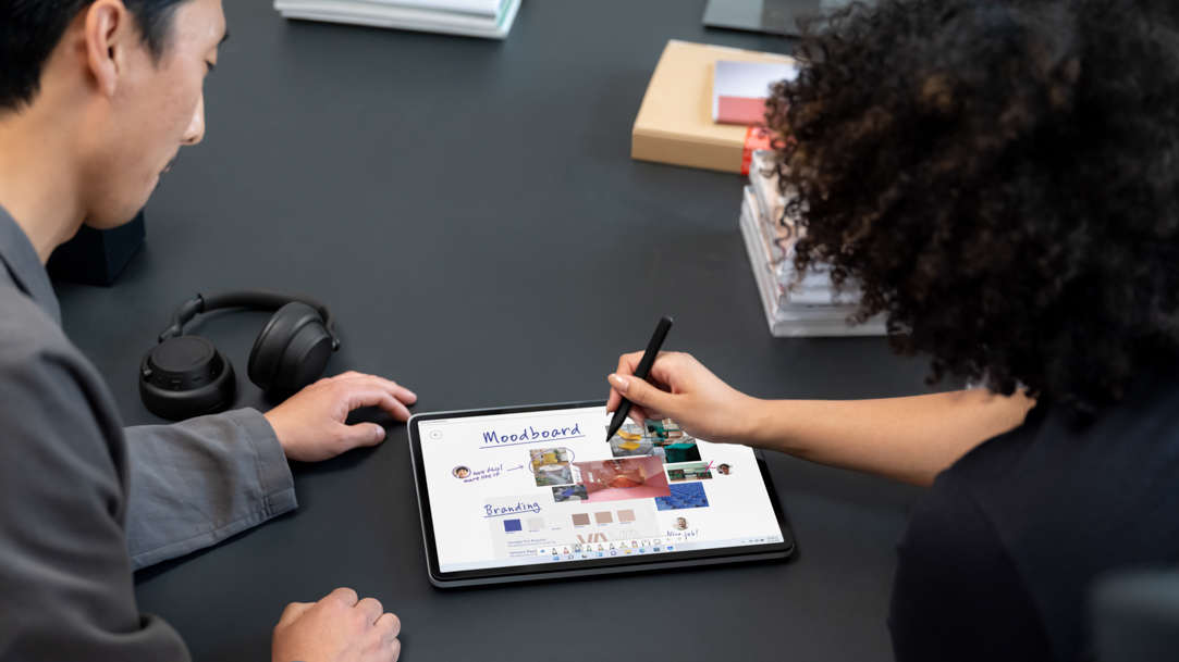 Two people using a stylus on Surface Laptop Studio