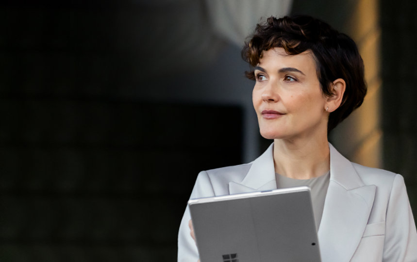 Woman holding Surface device while looking to her right reflectively