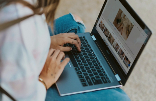 Woman in white long sleeve shirt using laptop