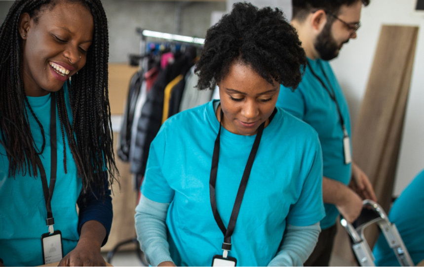 Three people in matching shirts and badges preparing a delivery