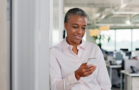 Businesswoman sending text message in office