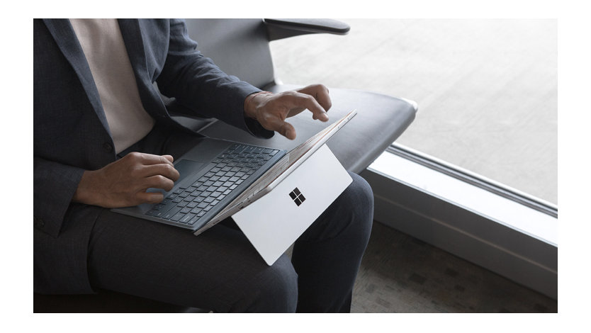 A person sits with a laptop resting on their lap