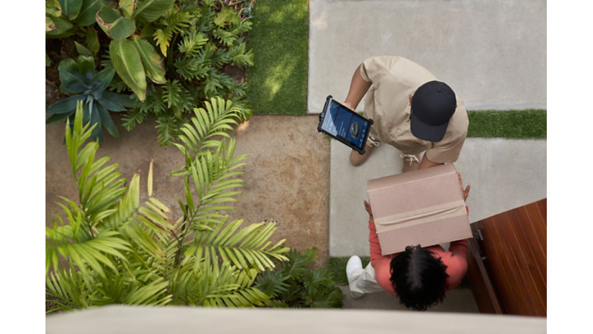 Delivery man dropping off a box at a woman’s front door.