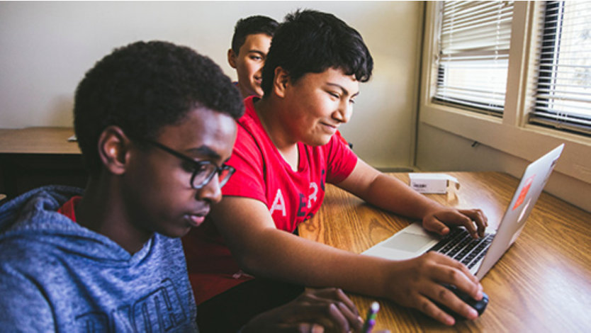 Two male high school students working together at a laptop in a TEALS computer science class