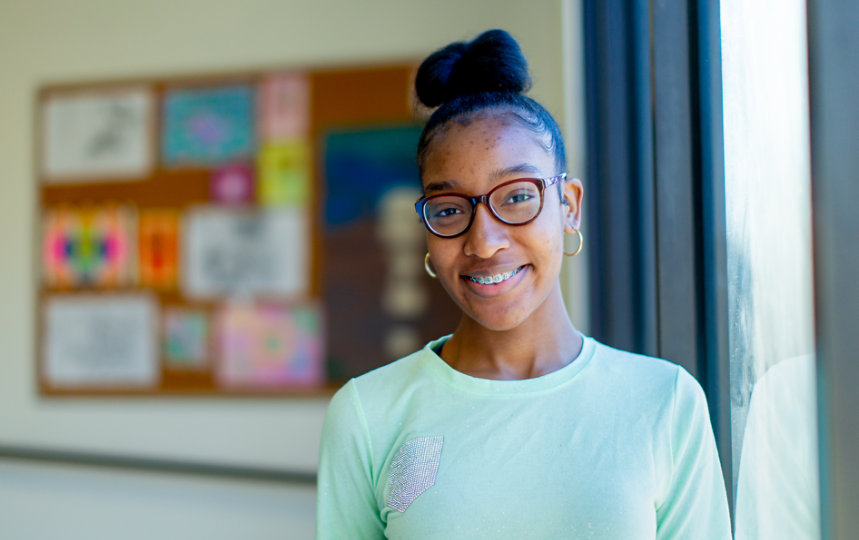 A young woman smiling in a classroom