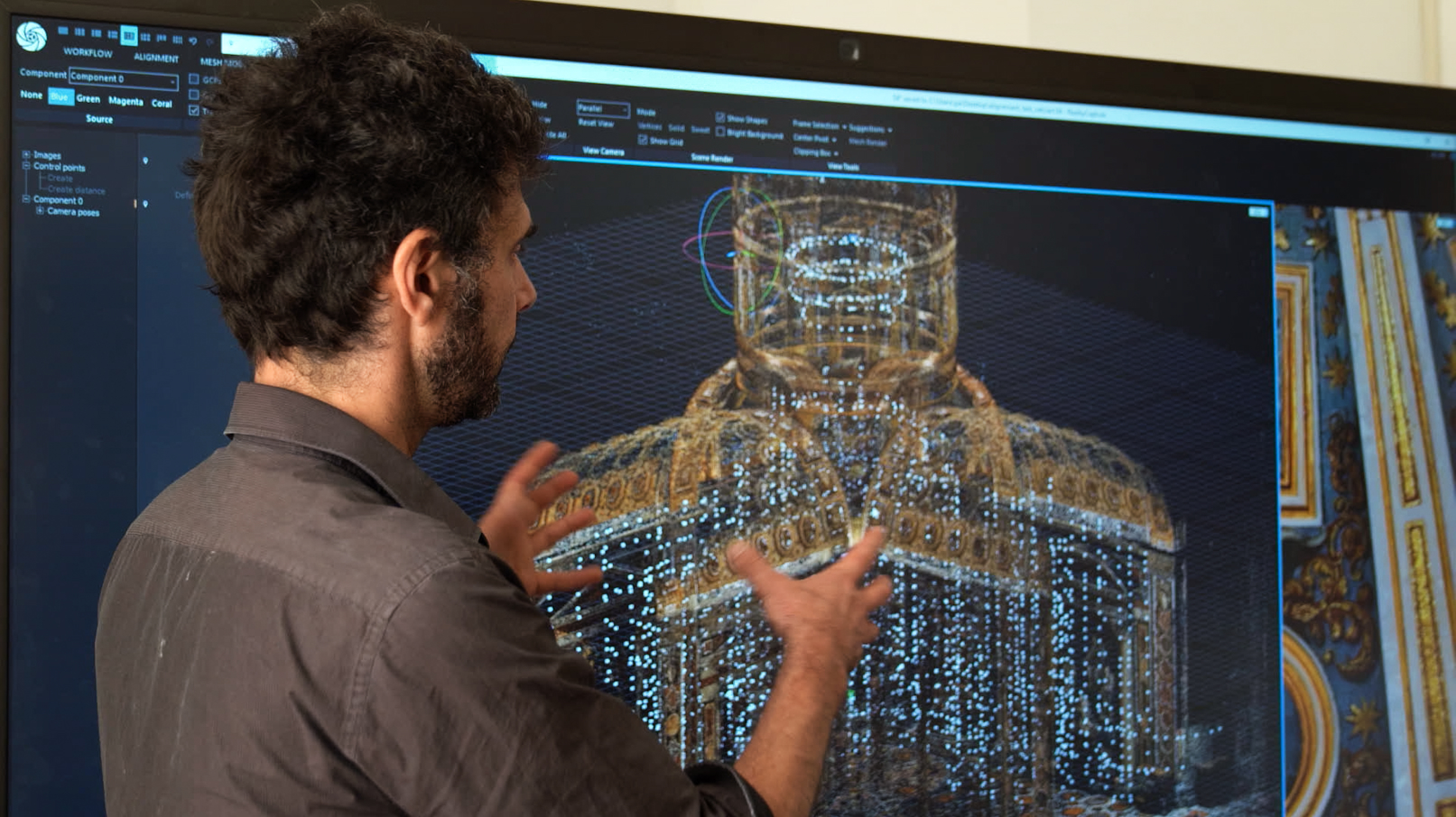 A man explains a 3D modeling software displaying a detailed architectural structure on a large screen.