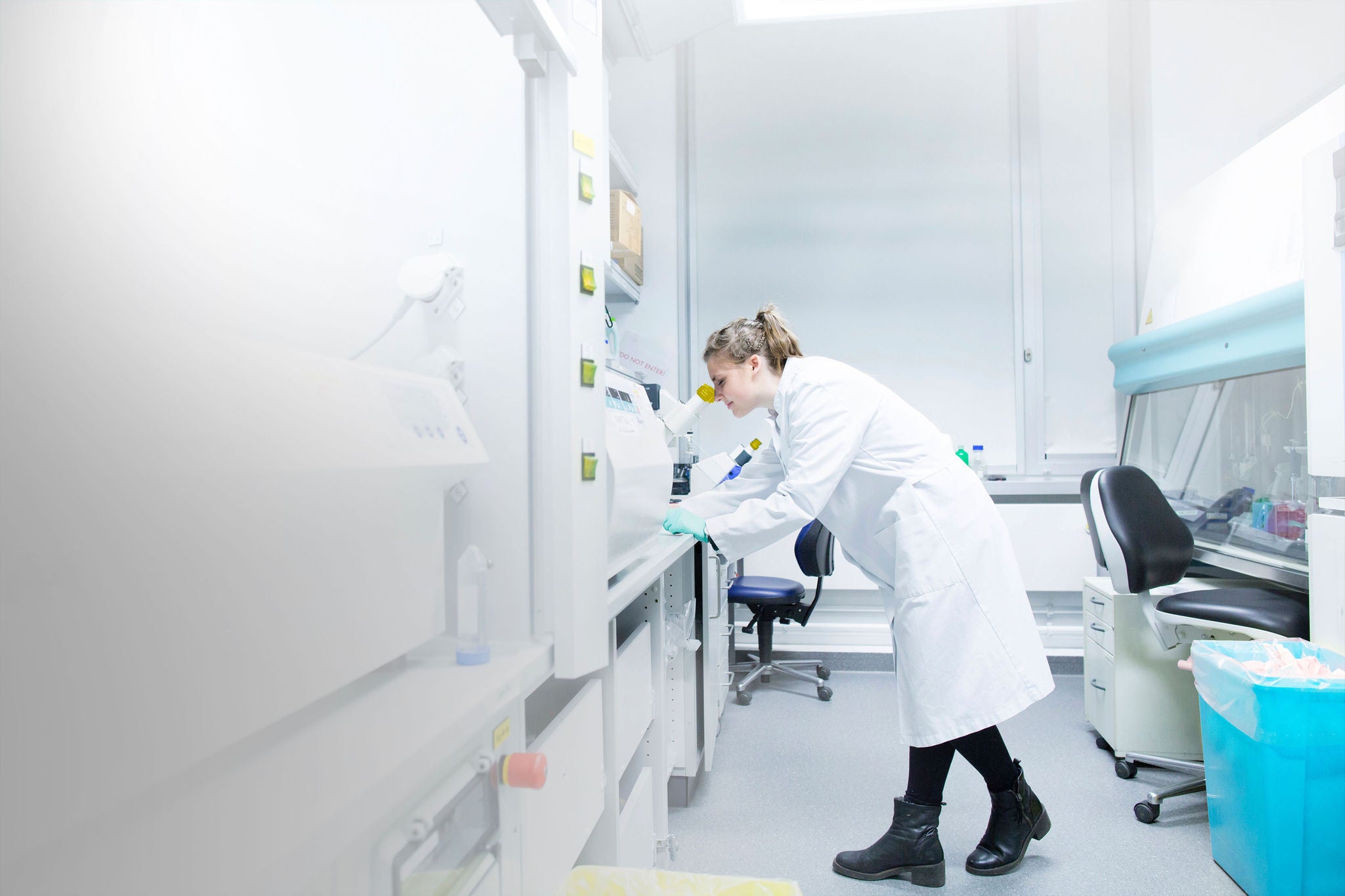 Young female scientist working at biological laboratory using microsope, Young female scientist working at biological laboratory using mi