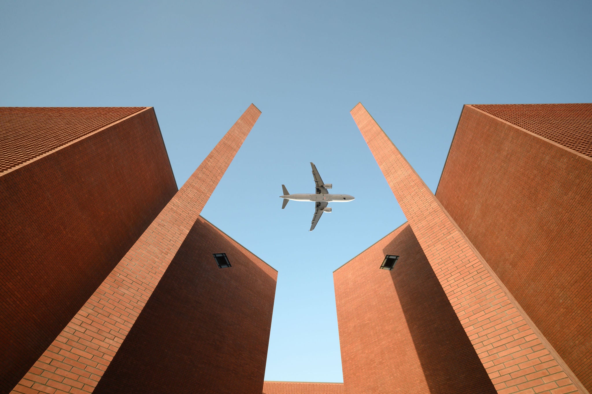 Modern building looking up to airplane