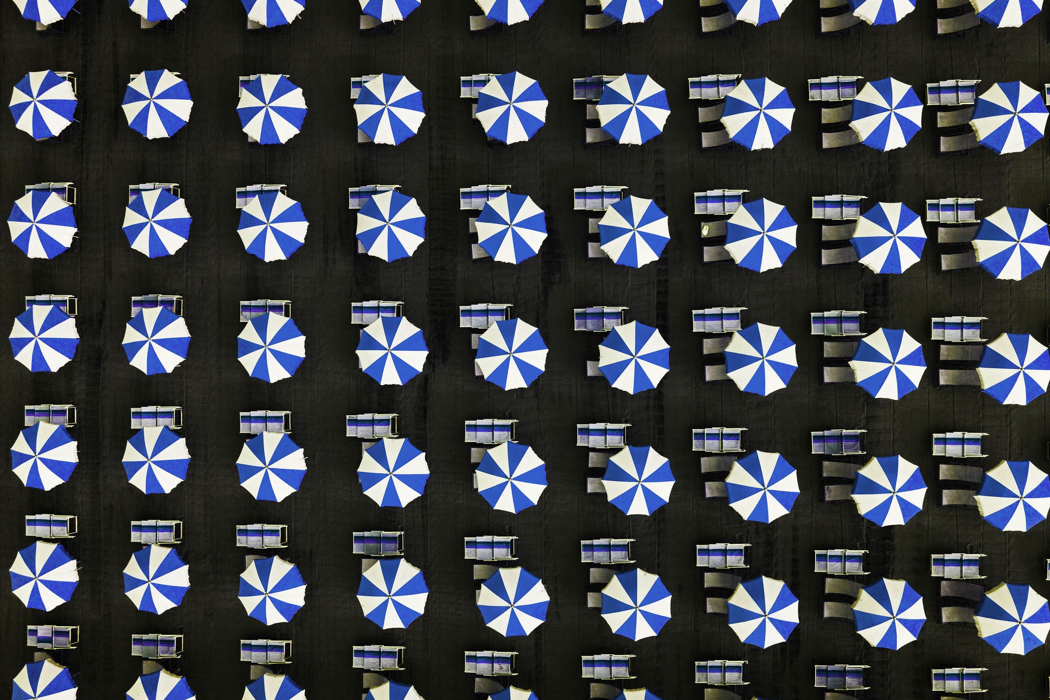 Symmetrical beach umbrellas as seen from directly above, Massa, Italy