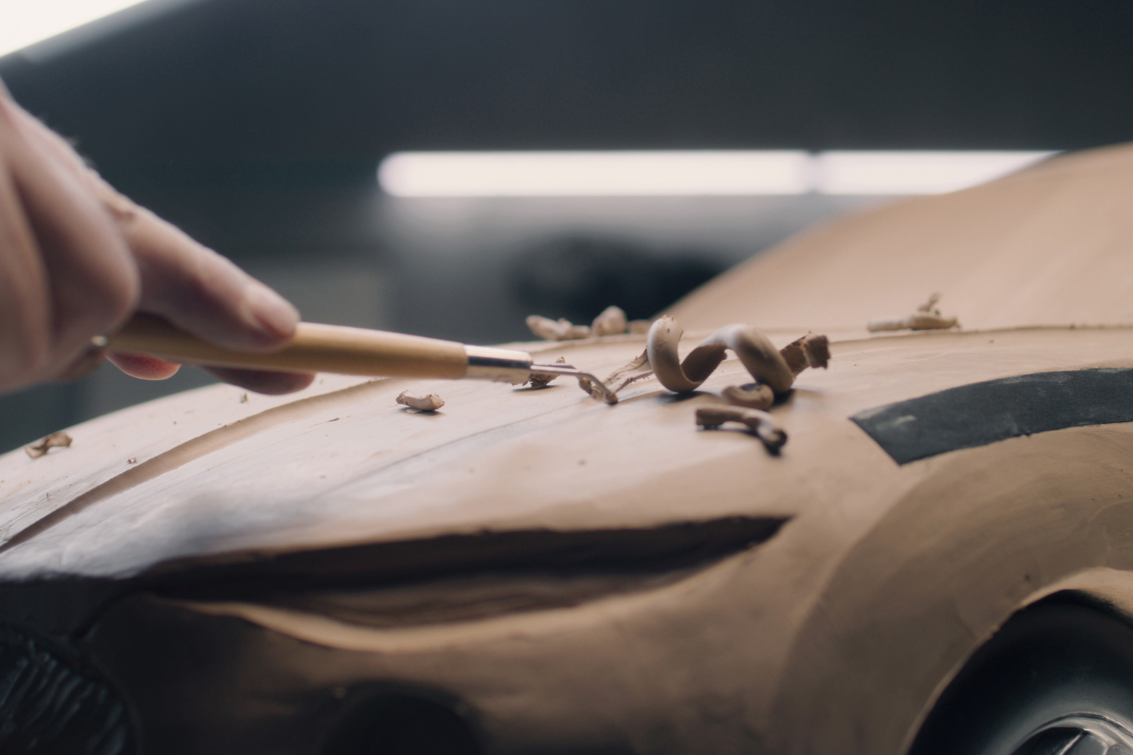 Man with rake working on clay car model