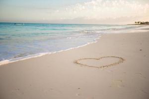 Heart drawn in the sand of a tropical beach photo