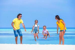 Family jumping rope on a beach photo