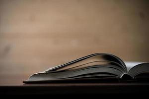 Close-up of an opened book on a wooden table photo