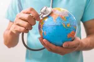 A man holding a stethoscope in front of a globe photo