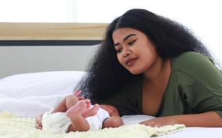 mamá disfruta jugando con su hijo recién nacido foto