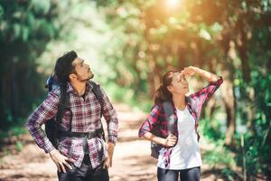 Young couple stop looking for something during hiking together. photo