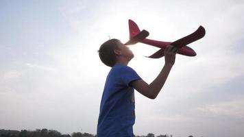 menino brincando com um avião de brinquedo em campos de verão video