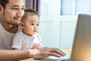 padre soltero e hijo usando laptop juntos felizmente foto