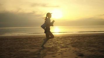 Slow-motion Side view Barefoot Woman running on the beach There are sea waves, there is a twilight light, the sun in the morning or the evening, lifestyle in vacation time. video