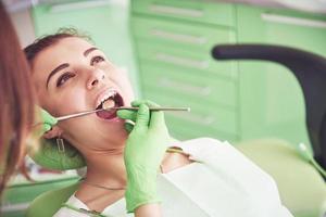 Dentist curing a female patient in the stomatology. Early prevention and oral hygiene concept photo