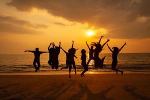 Silhouette photo of the team celebration on the beach at sunset