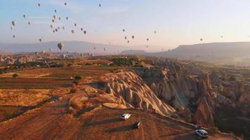 turista de vista aérea de pássaros no mirante assista balões de ar quente no céu ao nascer do sol na capadócia. destino de viagem na turquia 4k explore o conceito video