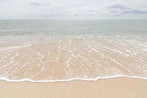 White clear sea water wave at beach sand photo