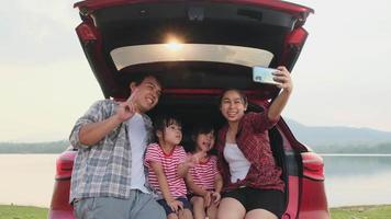 família feliz aproveitando a viagem nas férias de verão. a família viaja na estrada em seu carro favorito. conceito de família de férias e viagens. video