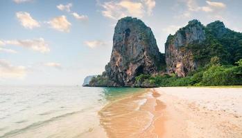 sea, beach and rocky mountains in tropical evening photo