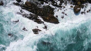 Drone top view of beautiful turquoise sea waves breaking on sandy coastline. Flying aerial shot of golden beach meeting deep blue ocean water and foamy waves. Nature, seascape, relaxing and summer. video