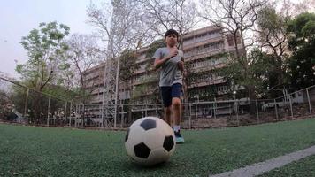 menino está jogando futebol futebol em campo verde - pessoas com conceito de sucesso de alvo de objetivo vencedor de esporte ao ar livre video