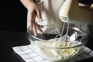 Lady making cake putting cream using spatula - homemade bakery cooking concept photo