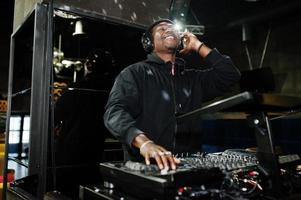 African american dj play music on decks at night club. photo