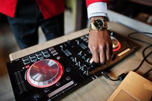 Hands of fashion african american man model DJ at red suit with dj controller. photo