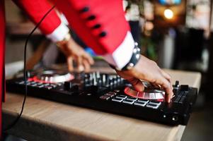 Hands of fashion african american man model DJ at red suit with dj controller. photo