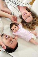 retrato interior con una familia joven feliz y un lindo bebé foto