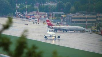 sochi, rússia, 27 de julho de 2022 - tiro no escuro, boeing 737 da nordwind chegou ao aeroporto de sochi. passageiros saem do avião. avião a jato na pista de táxi depois da chuva. conceito de turismo e viagens video