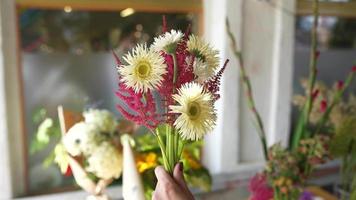 Florist arranges flowers for bouquet video