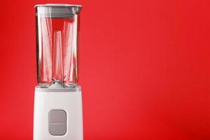 Blender with cup on red background with free space. photo